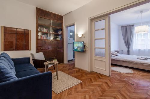 a living room with a couch and a bed and a tv at Lovely Art apartment - Victory in Varna City