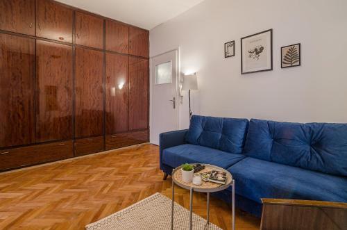 a living room with a blue couch and a table at Lovely Art apartment - Victory in Varna City