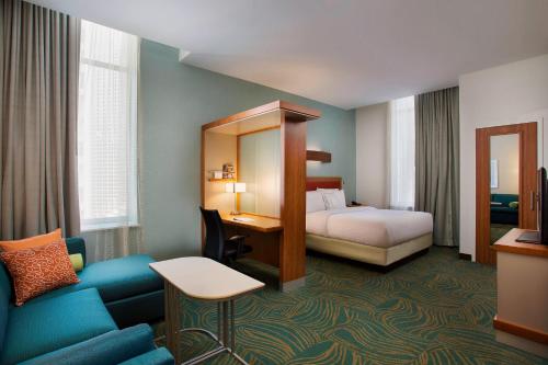 a hotel room with a bedroom with a bed and a couch at SpringHill Suites by Marriott Houston Downtown/Convention Center in Houston