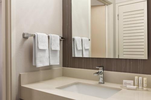 a bathroom with a sink and a mirror and towels at Courtyard Lubbock in Lubbock