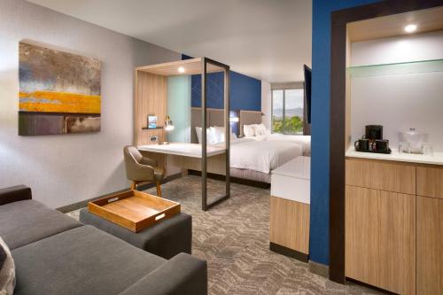 Habitación de hotel con sofá y cama en SpringHill Suites by Marriott Salt Lake City-South Jordan, en South Jordan