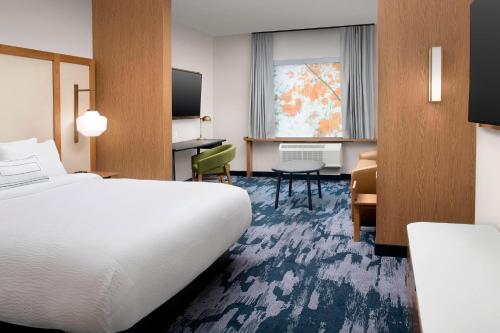 Fairfield Inn & Suites by Marriott New Orleans Metairie في ميتايري: غرفة في الفندق مع سرير ومكتب