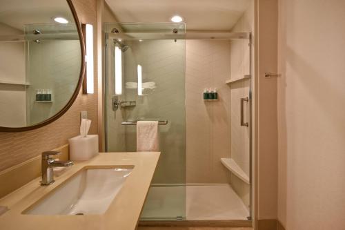 a bathroom with a sink and a shower with a mirror at Fairfield Inn & Suites by Marriott Milwaukee North in Glendale