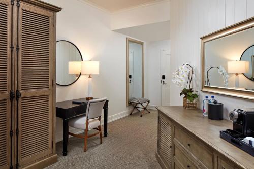 a hotel room with a desk and a mirror at Vespera Resort on Pismo Beach, Autograph Collection in Pismo Beach
