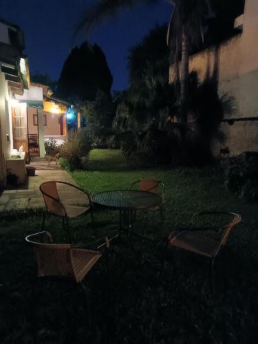 a table and chairs in a yard at night at La Cara Oculta de Salta Bed and Breakfast in Salta