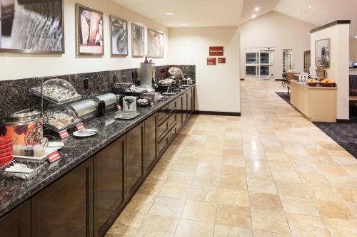 a large kitchen with a long counter with dishes at TownePlace Suites by Marriott San Antonio Airport in San Antonio