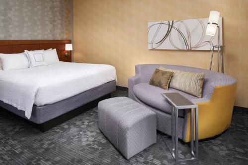 a hotel room with a bed and a chair at Courtyard by Marriott Lexington North in Lexington