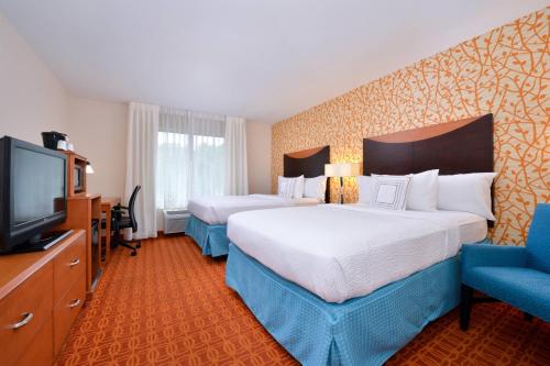 a hotel room with two beds and a flat screen tv at Fairfield Inn and Suites by Marriott Asheboro in Asheboro