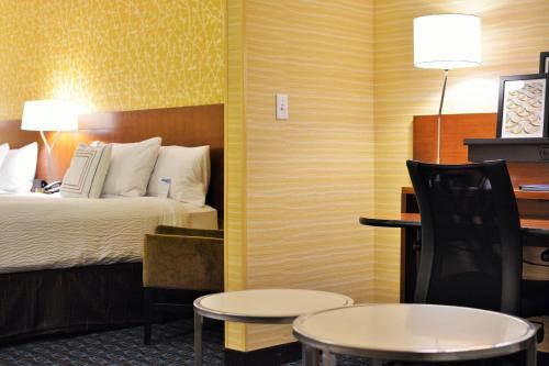 a hotel room with a bed and a table and chairs at Fairfield Inn & Suites by Marriott Omaha Northwest in Omaha