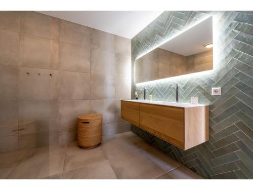ein Bad mit einem Waschbecken und einem Spiegel in der Unterkunft completely newly built modern holiday home in a quiet location in Kamperland
