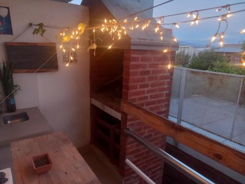 un patio con una chimenea de ladrillo con luces de Navidad en Depa9 en San Salvador de Jujuy