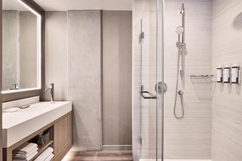 uma casa de banho com um chuveiro e um lavatório. em AC Hotel by Marriott Sunnyvale Moffett Park em Sunnyvale