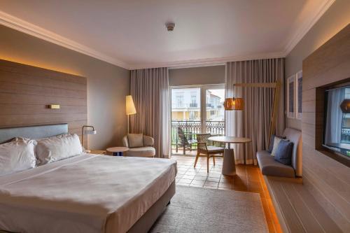 a hotel room with a bed and a balcony at Praia D'El Rey Marriott Golf & Beach Resort in Casal da Lagoa Seca