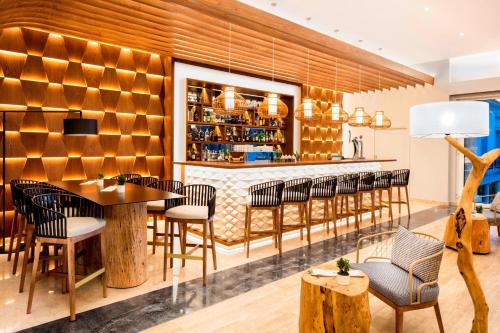 a restaurant with a bar with chairs and a table at Praia D'El Rey Marriott Golf & Beach Resort in Casal da Lagoa Seca