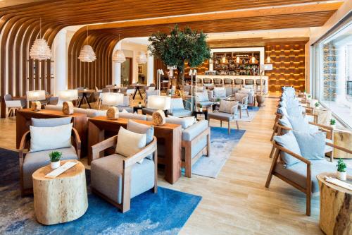 un restaurant avec des chaises et des tables ainsi qu'un bar dans l'établissement Praia D'El Rey Marriott Golf & Beach Resort, à Casal da Lagoa Seca