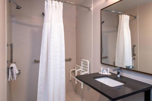a bathroom with a white shower curtain and a sink at Fairfield Inn & Suites High Point Archdale in Archdale