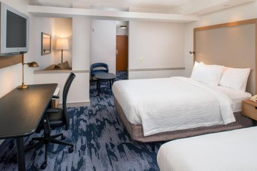 a hotel room with two beds and a desk at Fairfield Inn & Suites High Point Archdale in Archdale