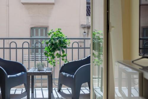 a balcony with chairs and a table with a plant at relax apartment inn in Catania