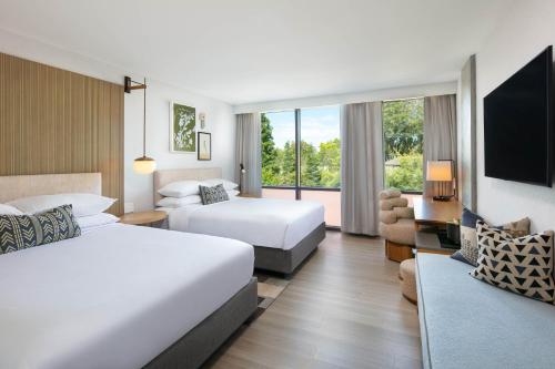 a hotel room with two beds and a couch at Hotel Citrine, Palo Alto, a Tribute Portfolio Hotel in Palo Alto