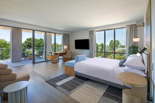 a bedroom with a large bed and a living room at Hotel Citrine, Palo Alto, a Tribute Portfolio Hotel in Palo Alto