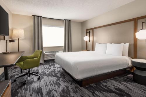 a hotel room with a bed and a desk and a chair at Fairfield Inn & Suites Findlay in Findlay
