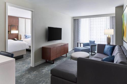 a hotel room with a couch and a bed and a mirror at Residence Inn by Marriott Washington Downtown/Convention Center in Washington