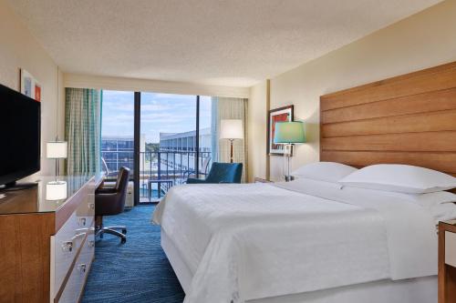 オーランドにあるSheraton Orlando Lake Buena Vista Resortの大型ベッドとテレビが備わるホテルルームです。