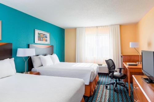 Habitación de hotel con 2 camas, escritorio y TV. en Fairfield Inn & Suites Lafayette en Lafayette