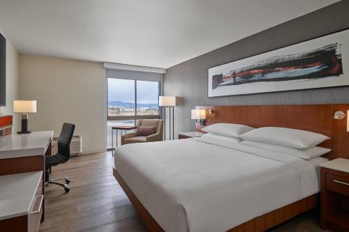 um quarto de hotel com uma cama grande e uma secretária em Delta Hotels by Marriott Denver Thornton em Westminster