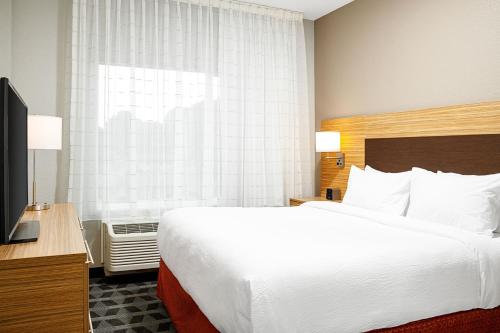 a hotel room with a large bed and a television at TownePlace Suites by Marriott Ironton in Ironton