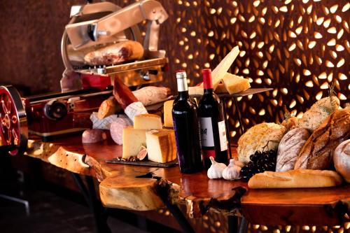 a table topped with lots of bread and wine bottles at AC Hotel Queretaro Antea in Querétaro
