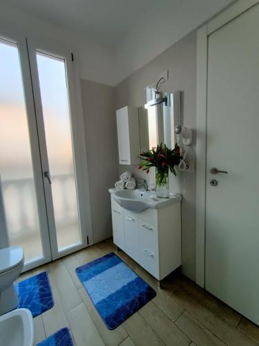 a bathroom with a sink and a toilet and a mirror at Arcobaleno Room Venezia-Mestre in Mestre