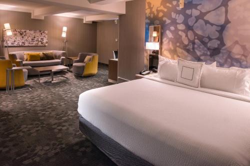 a hotel room with a bed and a living room at Courtyard by Marriott Oxnard/Ventura in Oxnard