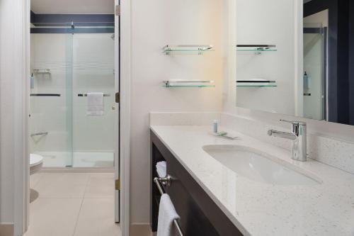 a white bathroom with a sink and a shower at Residence Inn Pinehurst Southern Pines in Southern Pines