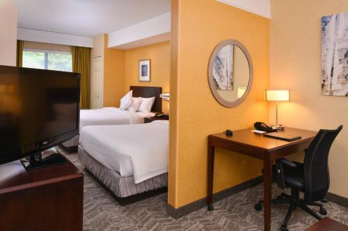 une chambre d'hôtel avec un lit et un bureau dans l'établissement SpringHill Suites Pittsburgh Mills, à Tarentum