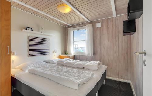 ヴィデ・サンデにあるNice Home In Hvide Sande With 4 Bedrooms, Sauna And Indoor Swimming Poolの窓付きの客室で、白い大型ベッド1台が備わります。