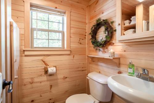 y baño con aseo blanco y lavamanos. en The Cabins at Panther Lake, 