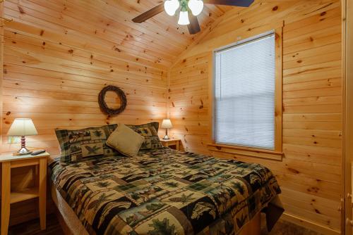 1 dormitorio con 1 cama en una cabaña de madera en The Cabins at Panther Lake, 