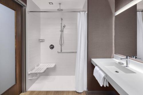 uma casa de banho com um chuveiro e um lavatório. em AC Hotel by Marriott Louisville Downtown em Louisville