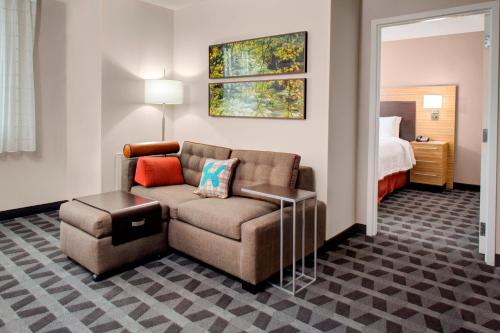 ein Wohnzimmer mit einem Sofa und einem Stuhl in einem Hotelzimmer in der Unterkunft TownePlace Suites by Marriott Parkersburg in Parkersburg