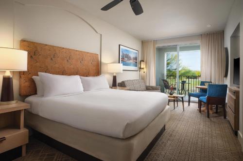 a bedroom with a large white bed and a living room at Marriott's Canyon Villas in Phoenix