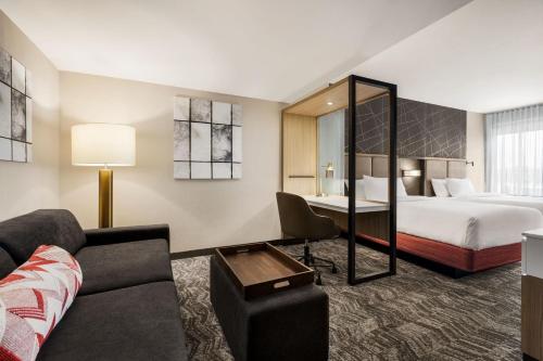 une chambre d'hôtel avec un lit et un canapé dans l'établissement SpringHill Suites by Marriott Camp Hill, à Camp Hill