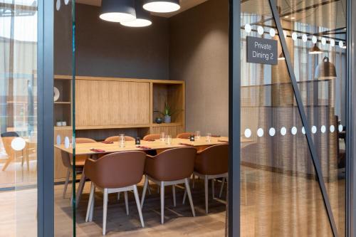 a dining room with a table and chairs and a sign that reads pirates drug at Courtyard by Marriott Glasgow SEC in Glasgow
