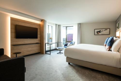 a hotel room with a bed and a flat screen tv at Courtyard by Marriott Glasgow SEC in Glasgow