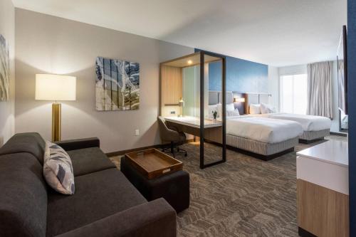 pokój hotelowy z kanapą i łóżkiem w obiekcie SpringHill Suites Minneapolis Maple Grove/Arbor Lakes w mieście Maple Grove