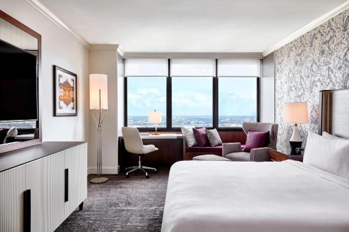 ニューオーリンズにあるJW マリオット ニュー オリンズのベッドとリビングルームが備わるホテルルームです。