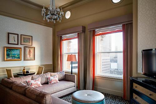 a living room with a couch and a tv at Hotel ICON, Autograph Collection in Houston