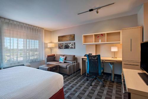 um quarto de hotel com uma cama, uma secretária e uma cadeira em TownePlace Suites Fayetteville Cross Creek em Fayetteville