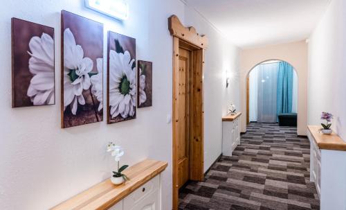 a hallway with flowers paintings on the wall at Mountain view apartments in Bad Mitterndorf