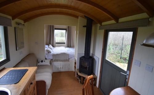 a room with a couch and a stove in a room at Forton House Shepherd's Huts in Chard